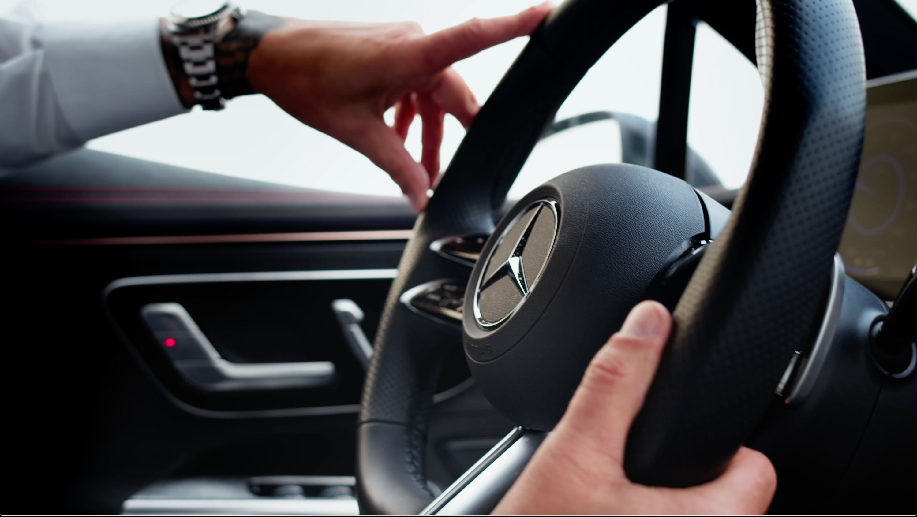 mand holder på rattet af Mercedes-elbil